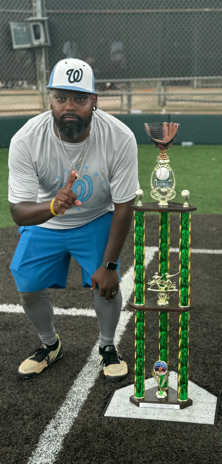 Terrance Robinson beside a baseball trophy
